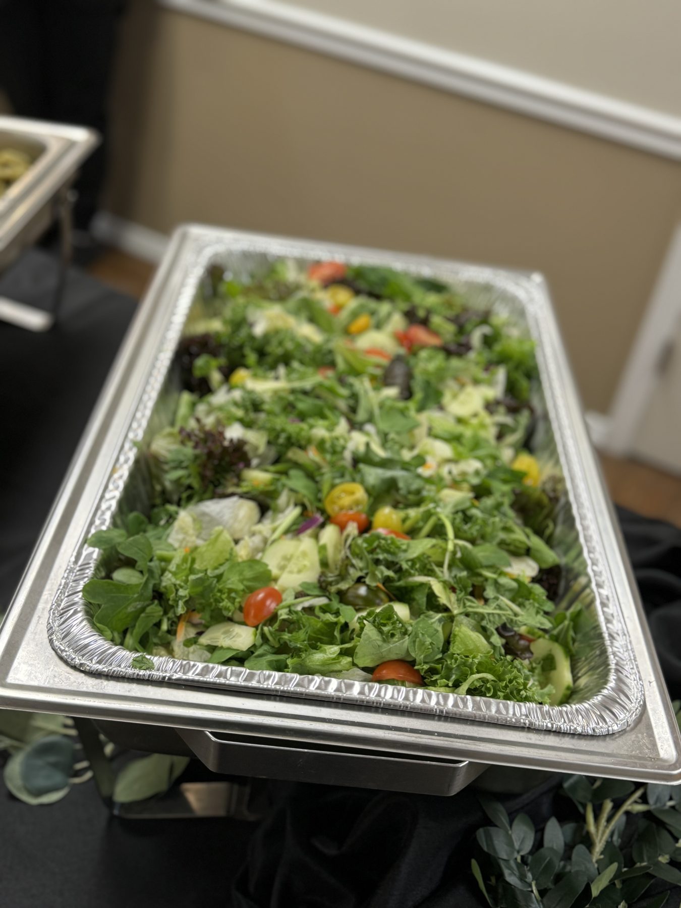 Large tray of fresh salad with cucumbers and tomatoes
