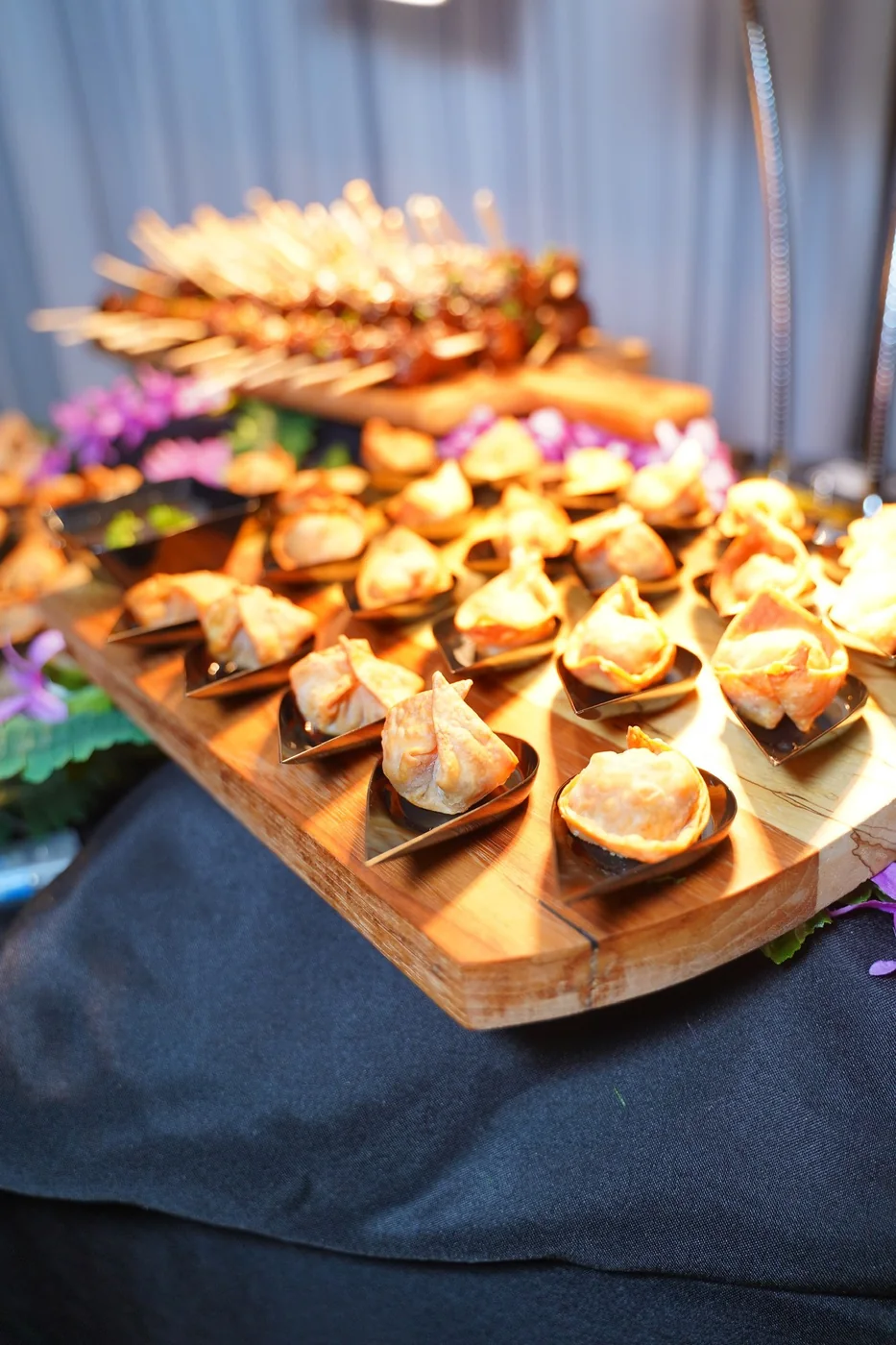 Cocktail-hour appetizers arranged on an elevated wooden display