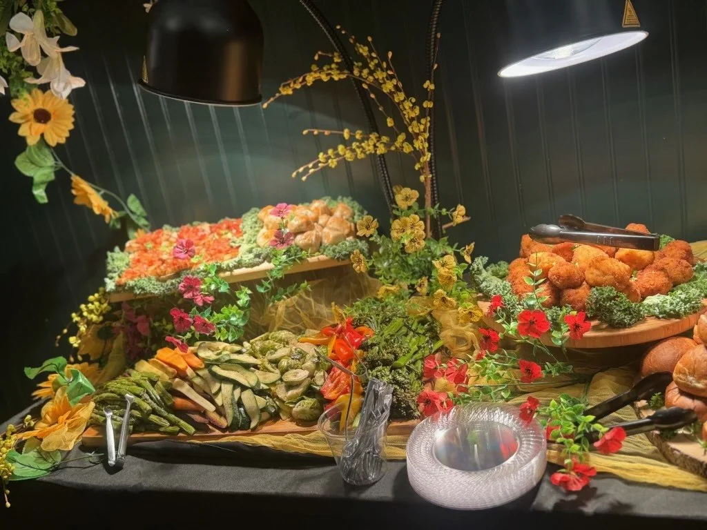 An elegant catered grazing table filled with colorful appetizers and fresh produce