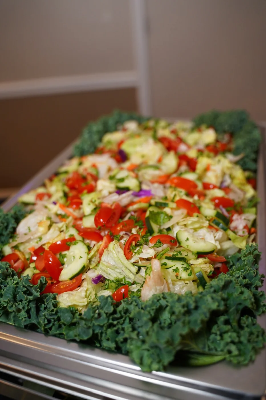 A colorful garden salad presented on a bed of fresh kale